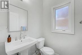 Barrie (Painswick South) apartment for rent - A white bathroom with a toilet, sink, and mirror.