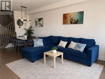 Milton (Bw Bowes) townhouse for rent - A living room with a blue couch and a wooden coffee table.