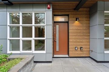North Vancouver apartment for rent - A modern house with a brown door and a red fire alarm on the wall.