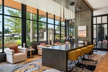 Bellevue apartment for rent - A modern living room with a long wooden table and yellow chairs.