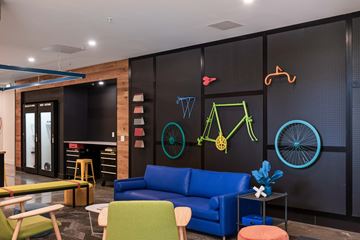 Seattle apartment for rent - A modern living room with a blue couch and a neon sign.