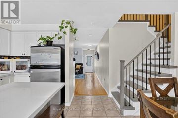 Milton (De Dempsey) apartment for rent - A white kitchen with a stainless steel refrigerator and a wooden chair.