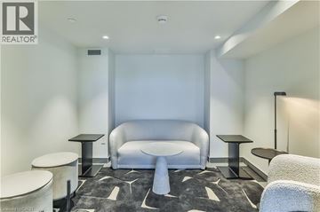 Hamilton condo for rent - A modern living room with a grey sofa and a black and white rug.