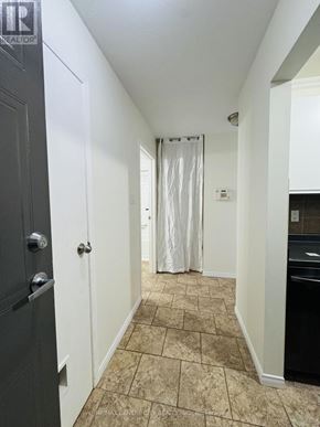 London South (South X) condo for rent - A hallway with a black door and a white door with a curtain.