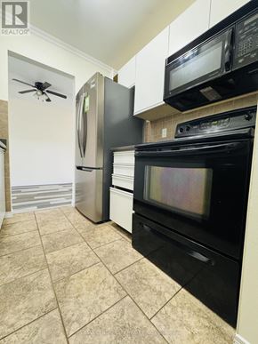 London South (South X) condo for rent - A black stove and oven in a kitchen with a fan on the ceiling.