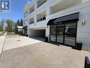 Fort Erie (Ridgeway) condo for rent - A white building with a black awning and glass doors.