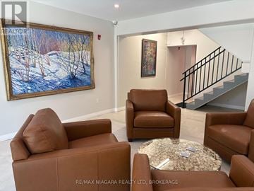 Fort Erie (Ridgeway) condo for rent - A living room with brown leather furniture and a painting on the wall.