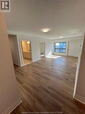 Windsor condo for rent - A room with wooden flooring and a window with white blinds.