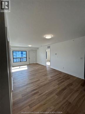 Windsor condo for rent - A room with wooden floors and white walls.