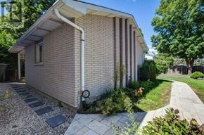 Ottawa apartment for rent - A house with a white roof and a brick wall with a white pipe running along it.