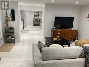 Toronto (Lansing-Westgate) apartment for rent - A living room with a grey couch and a wooden cabinet.
