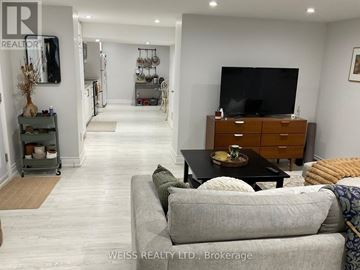 Toronto (Lansing-Westgate) apartment for rent - A living room with a grey couch and a wooden cabinet.