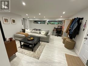 Toronto (Lansing-Westgate) apartment for rent - A well-lit living room with a couch, coffee table, and a wall-mounted coat rack.