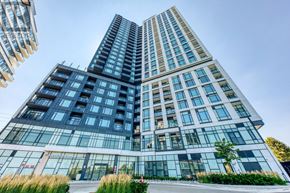 Mississauga (Central Erin Mills) condo for rent - A modern glass building with a clear blue sky in the background.