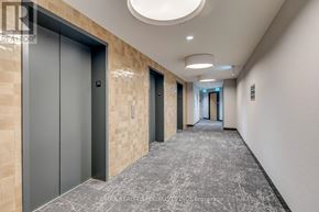 Mississauga (Central Erin Mills) condo for rent - A long hallway with a carpeted floor and a ceiling light.