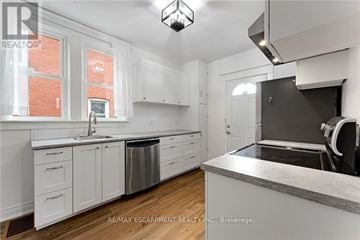 Welland (Broadway) apartment for rent - A kitchen with white cabinets and a marble countertop.