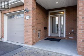 Ottawa townhouse for rent - A brick house with a white garage door and a black mat in front of it.