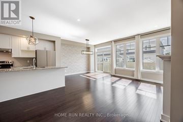 Ottawa townhouse for rent - A modern kitchen with white cabinets and a wooden floor.