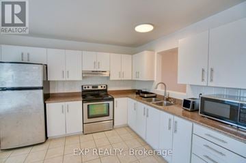 Ottawa townhouse for rent - A kitchen with white cabinets and appliances is for sale.