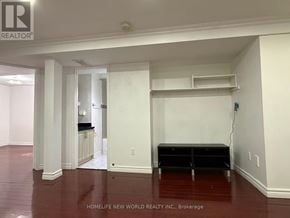 Markham (Middlefield) apartment for rent - A room with white walls and a wooden floor with a Realty logo on the top left corner.