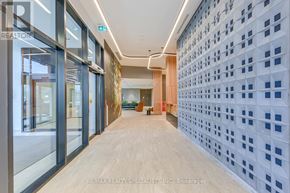 Mississauga (Central Erin Mills) condo for rent - A hallway with a wall of windows and a wall of blue squares.