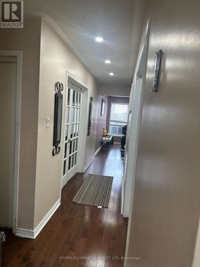 Mississauga (Meadowvale) apartment for rent - A hallway with a rug on the floor and a door on the left.