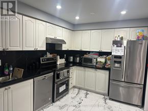 Mississauga (Meadowvale) apartment for rent - A kitchen with black countertops and white cabinets.