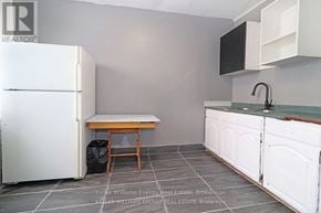 Oshawa (Central) apartment for rent - A kitchen with a white fridge, a table and a sink.