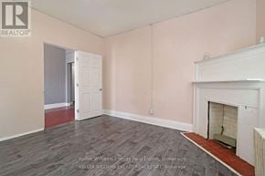 Oshawa (Central) apartment for rent - A room with a fireplace and a door leading to another room.