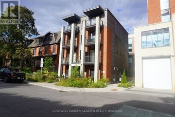 Ottawa apartment for rent - A building with a balcony is in the middle of a street.