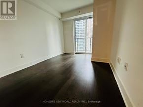 Toronto (Bay Street Corridor) condo for rent - A room with wooden flooring and a window with blinds.