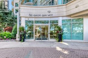 Toronto (Waterfront Communities) condo for rent - The entrance to the Gold Queens Quay West building is framed by two large planters with flowers.