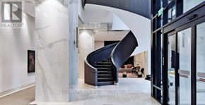 Toronto (Islington-City Centre West) condo for rent - A modern interior space with a marble wall and a curved staircase.