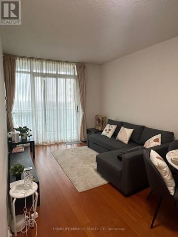 Mississauga (City Centre) condo for rent - A living room with a grey couch and a white chair.