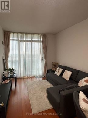 Mississauga (City Centre) condo for rent - A living room with a grey couch and a wooden floor.