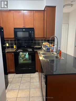 Mississauga (City Centre) condo for rent - A black stove top oven sitting under a microwave in a kitchen.