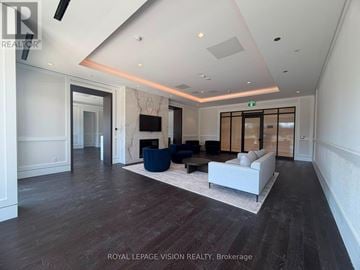 Toronto (Humber Heights) condo for rent - A spacious living room with a white sofa and a television.