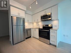 Toronto (Humber Heights) condo for rent - A kitchen with white cabinets and stainless steel appliances.