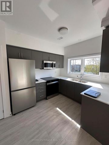 Guelph (Clairfields/Hanlon Business Park) townhouse for rent - A kitchen with a refrigerator, microwave, and sink.