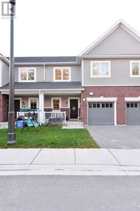 Shelburne townhouse for rent - A grey house with a red brick base and a black door.