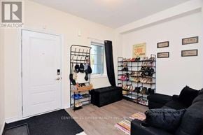 Shelburne townhouse for rent - A room with a black couch, a shoe rack, and a door.
