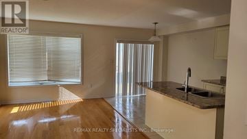 Haldimand townhouse for rent - A kitchen with a counter and a window with blinds.