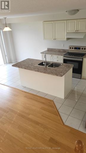 Haldimand townhouse for rent - A kitchen with a granite countertop and white cabinets.