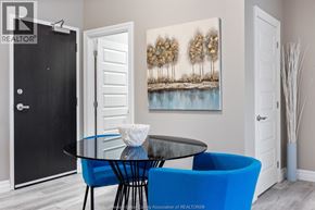 Tecumseh condo for rent - A modern dining room with a glass table and blue chairs.