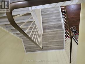 Toronto (Tam O'shanter-Sullivan) condo for rent - A staircase with a wooden handrail and white steps.