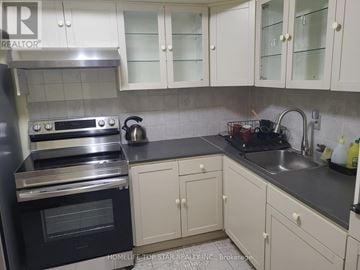 Toronto (Tam O'shanter-Sullivan) condo for rent - A kitchen with white cabinets and a black oven.