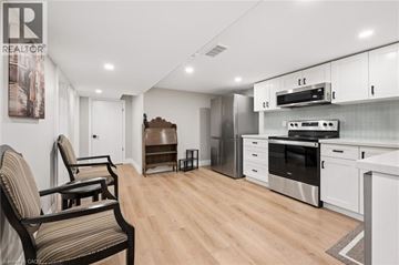 Kitchener apartment for rent - A modern kitchen with a striped chair and stainless steel appliances.