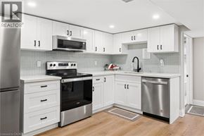 Kitchener apartment for rent - A modern kitchen with white cabinets and stainless steel appliances.