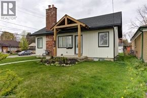 Kitchener apartment for rent - A house with a brown brick chimney and a white exterior is shown.