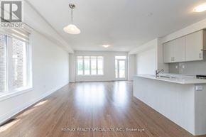 Brampton (Bram West) townhouse for rent - A spacious room with wooden floors and white walls.